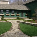 Side entrance with newly planted landscaping and sod.